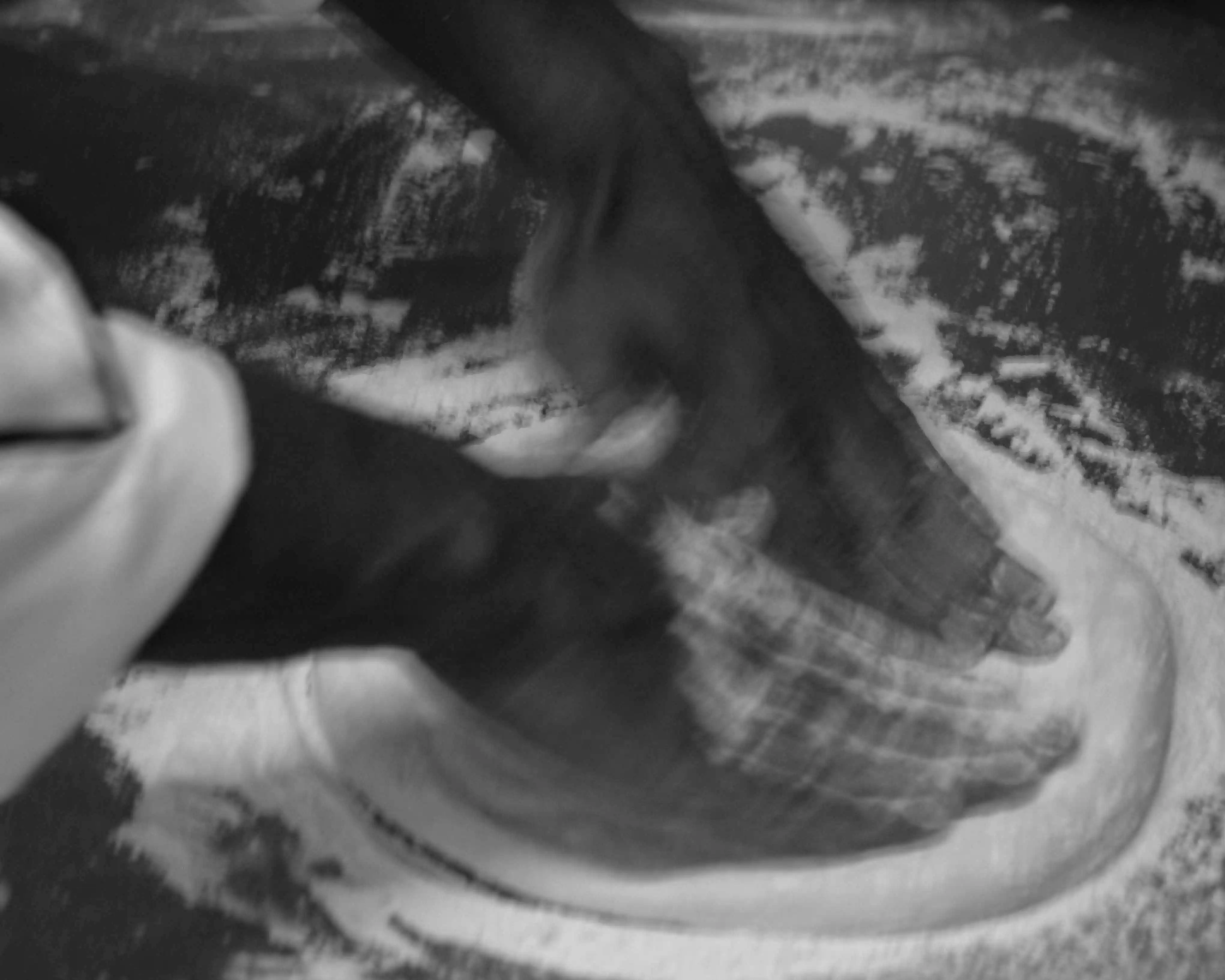 Massa de pizza sendo aberta à mão