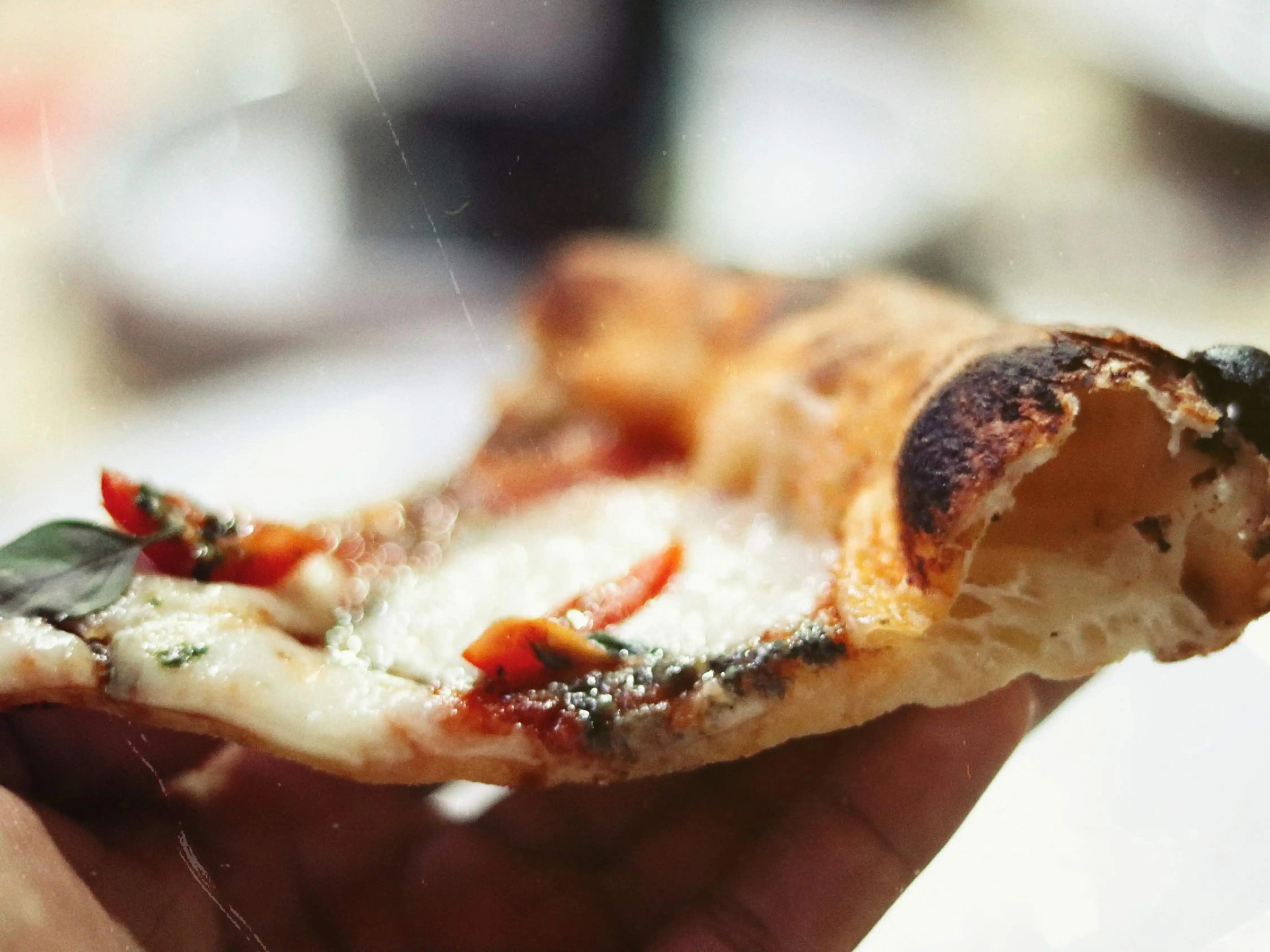 Fatia de pizza artesanal da Nomad, mostrando a borda aerada